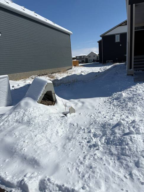 Before — snow-covered lot with fallen sign